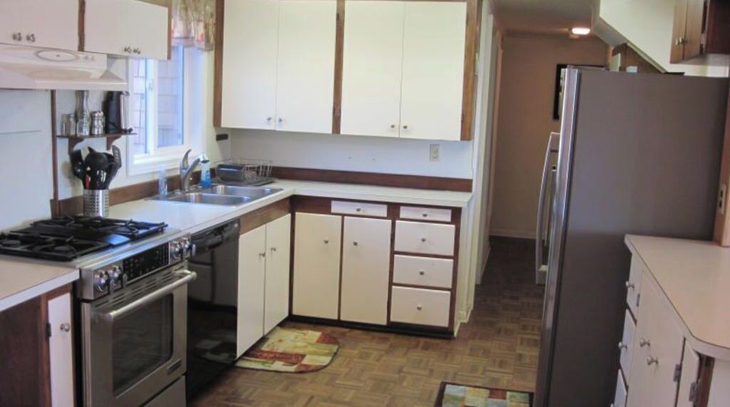 A compact kitchen with a stove, sink, and cabinets.