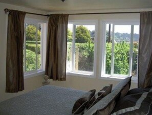 Relax in this serene bedroom with a large bed and stunning garden views.