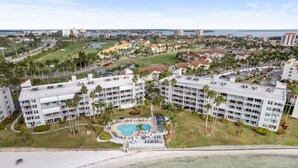 Ein Hotel mit mehreren Gebäuden, einem Schwimmbad und Blick auf den Strand.