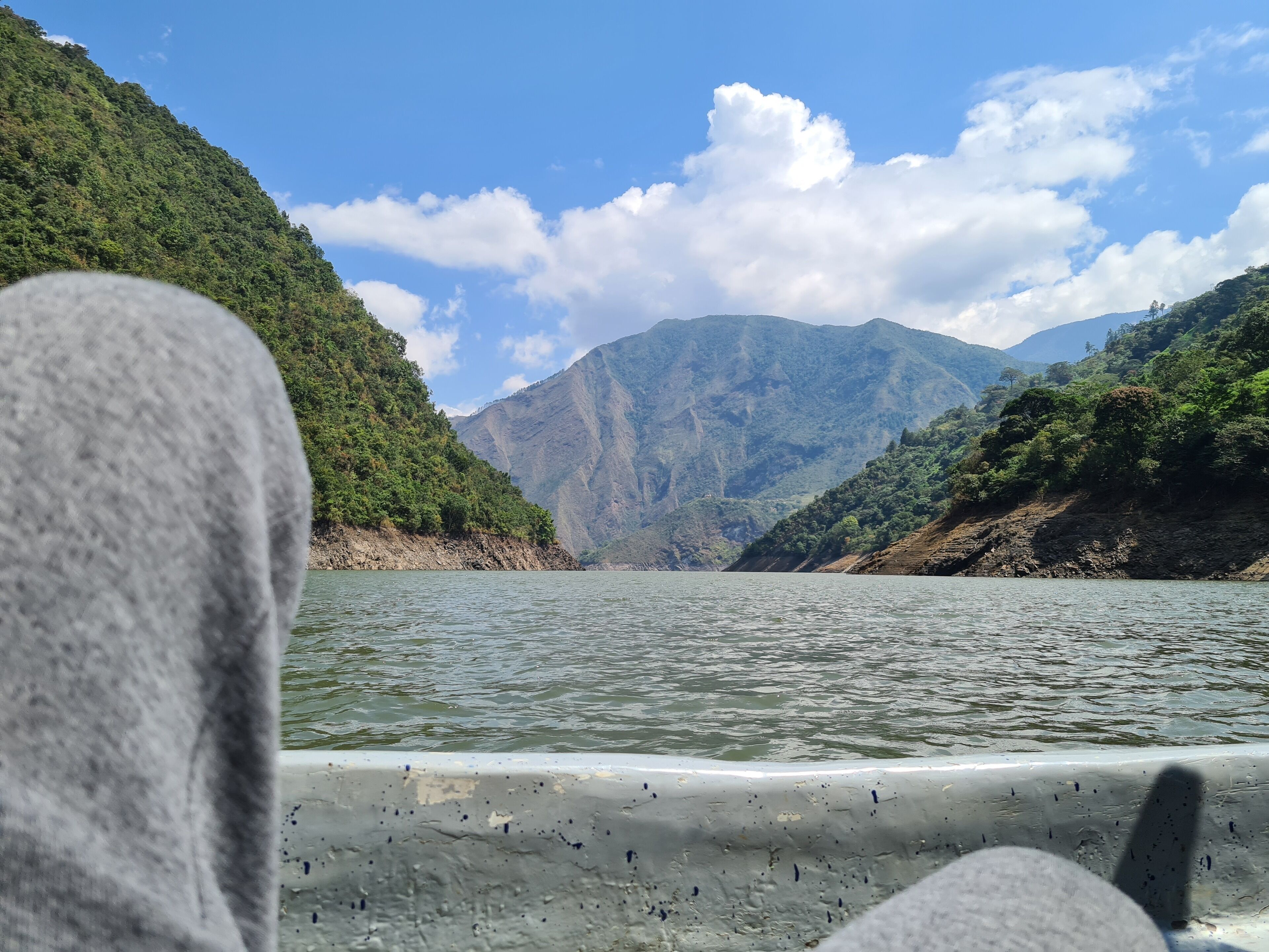 Un bote en un río tranquilo con montañas al fondo.