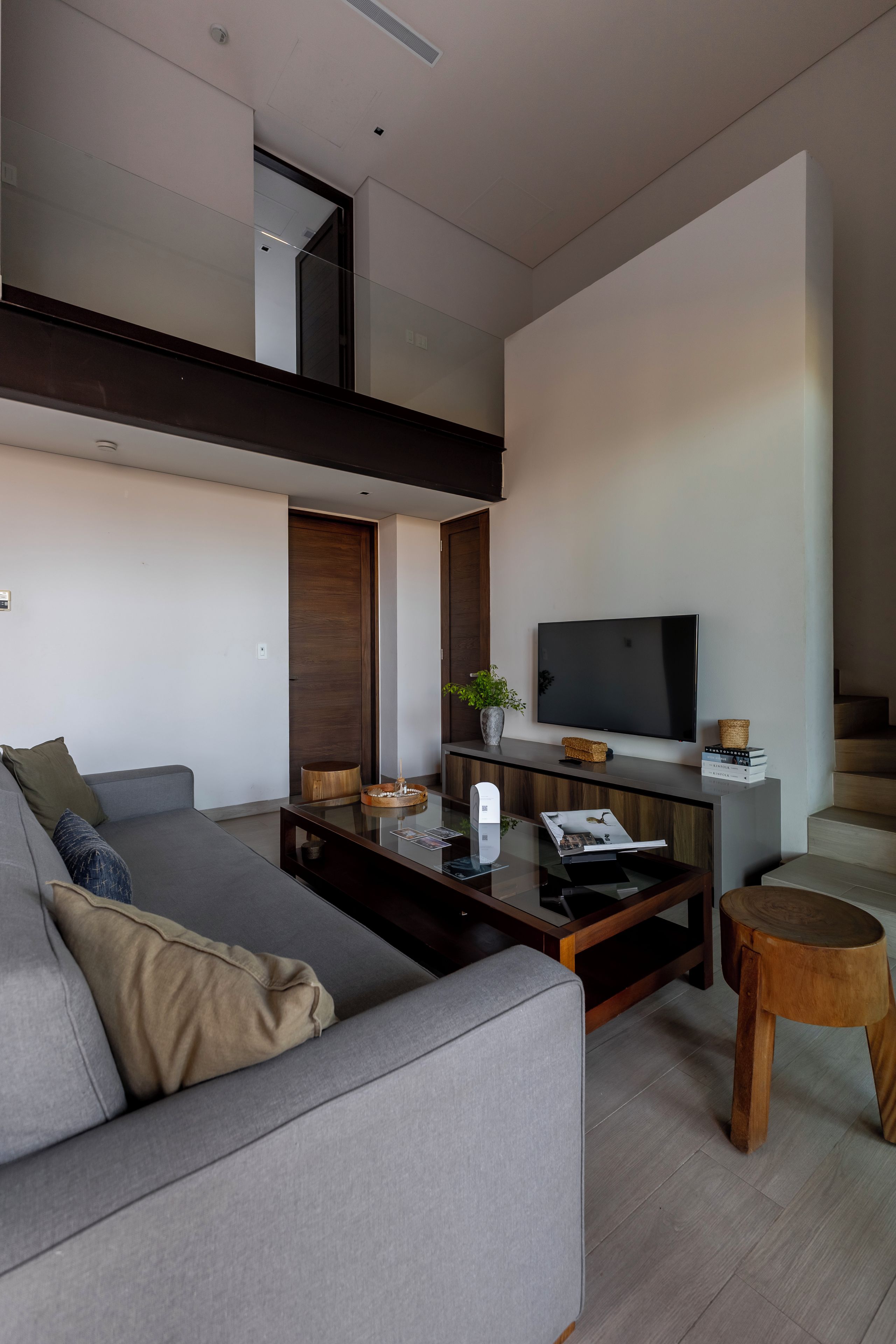 Un salon moderne avec un canapé, une table basse et un téléviseur à écran plat.