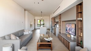 Ein modernes Wohnzimmer mit einer Couch, einem Couchtisch und einem Fernseher.
