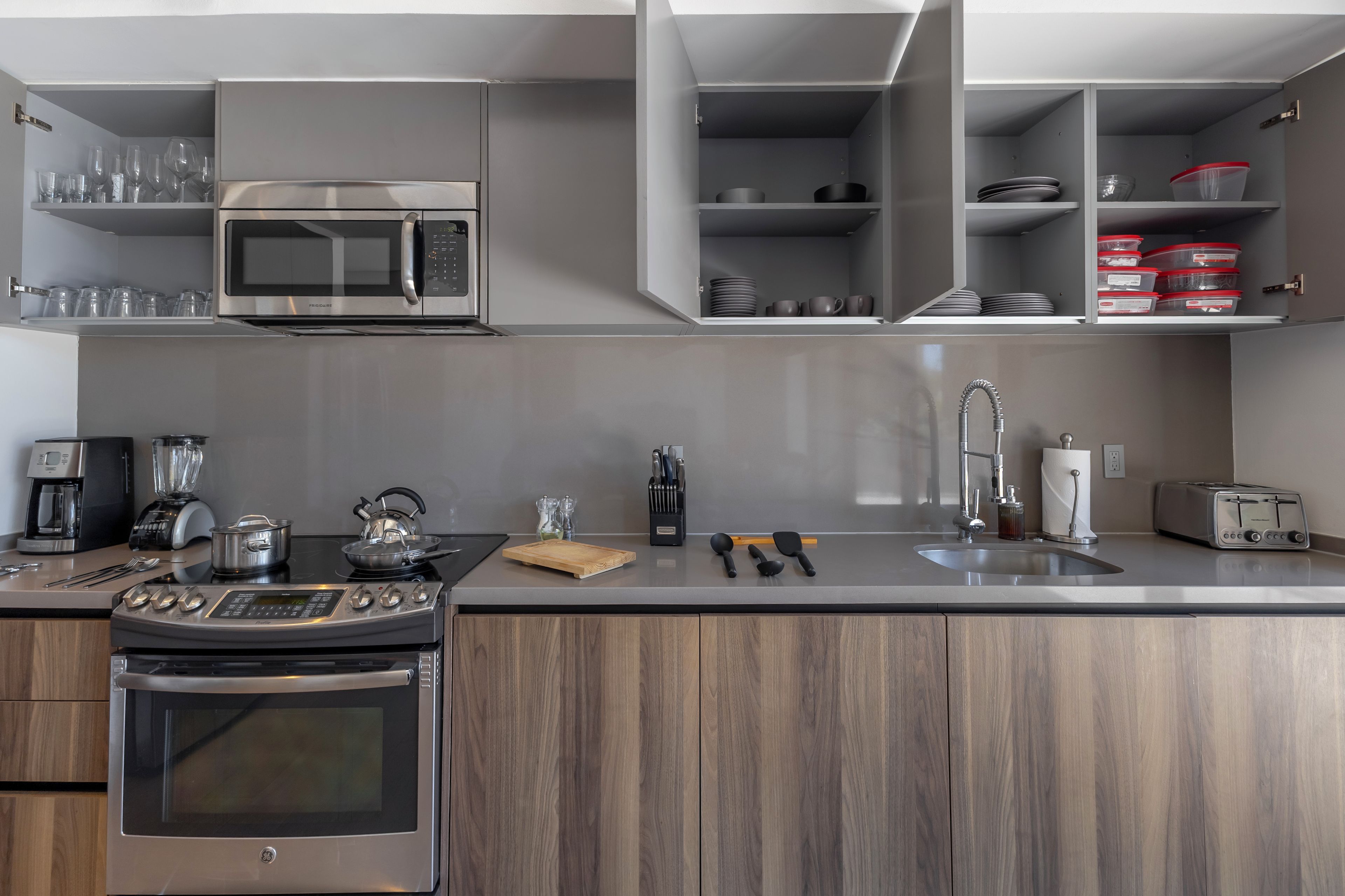 Uma cozinha moderna com eletrodomésticos embutidos, bancada de madeira e forno de aço inoxidável.