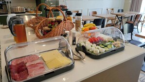Un bufet de l'esmorzar amb diversos aliments, incloent carns, formatges, fruites i verdures.