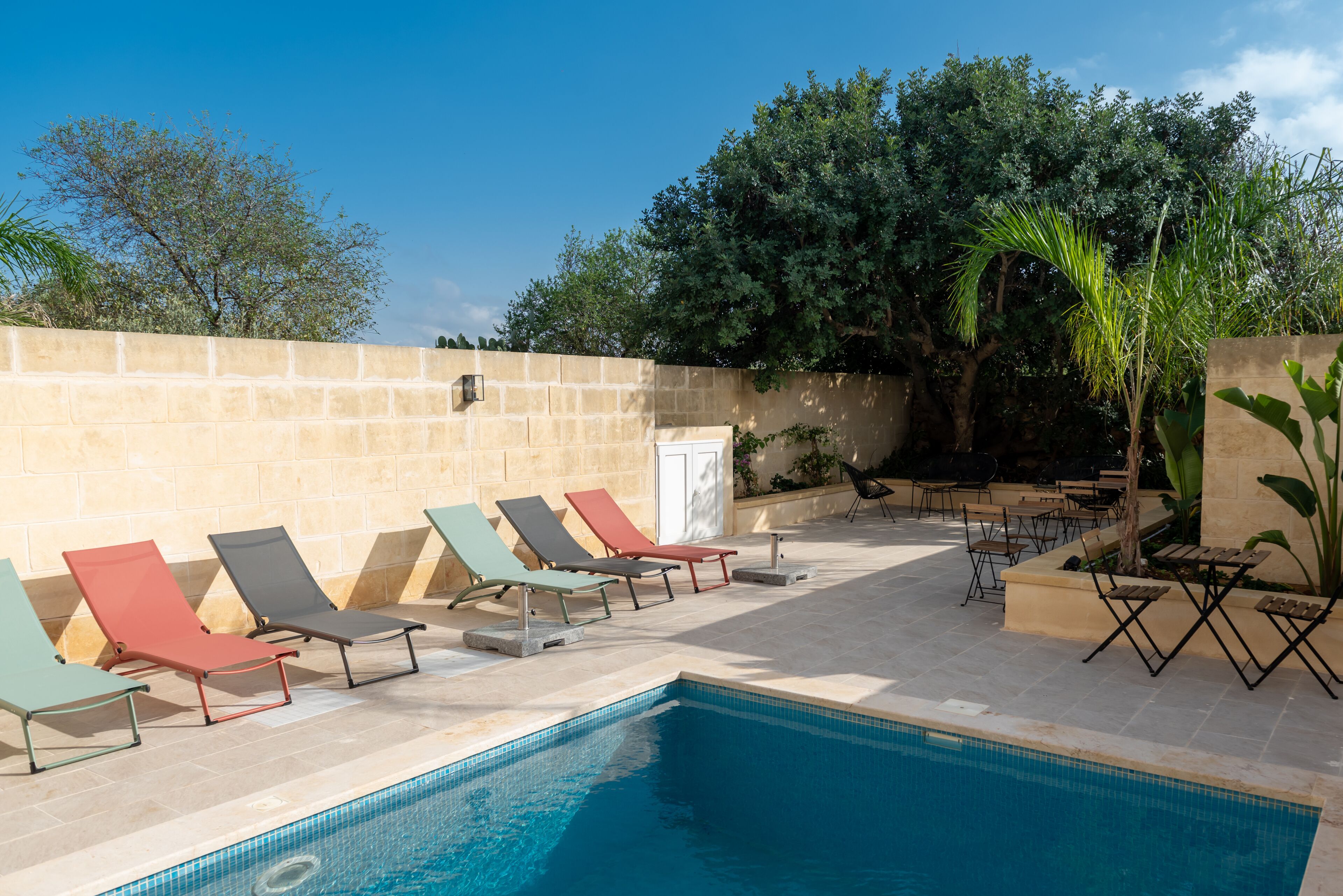 A poolside area with lounge chairs and a swimming pool.