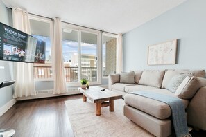 Een moderne woonkamer met een bank, salontafel en een televisie.