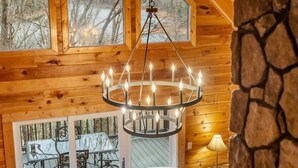 Un intérieur en bois agrémenté d’un lustre, de grandes fenêtres et d’un mur en pierre.