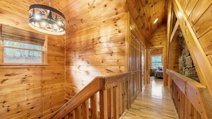 Un intérieur en bois avec un escalier, des murs en bois et un mur de pierres en arrière-plan.