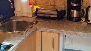 A kitchen with wooden cabinets, a stainless steel sink, a microwave, a coffee maker, and a dishwasher. - farm💗 for families and vacationers with pets (Eppan)