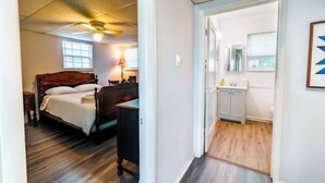 Une chambre à coucher avec un lit en bois, un ventilateur de plafond et une fenêtre.