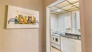 Une cuisine avec des meubles blancs, une cuisinière et un évier.