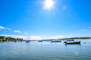 Ein Yachthafen mit mehreren Booten, die unter blauem Himmel vor Anker liegen.