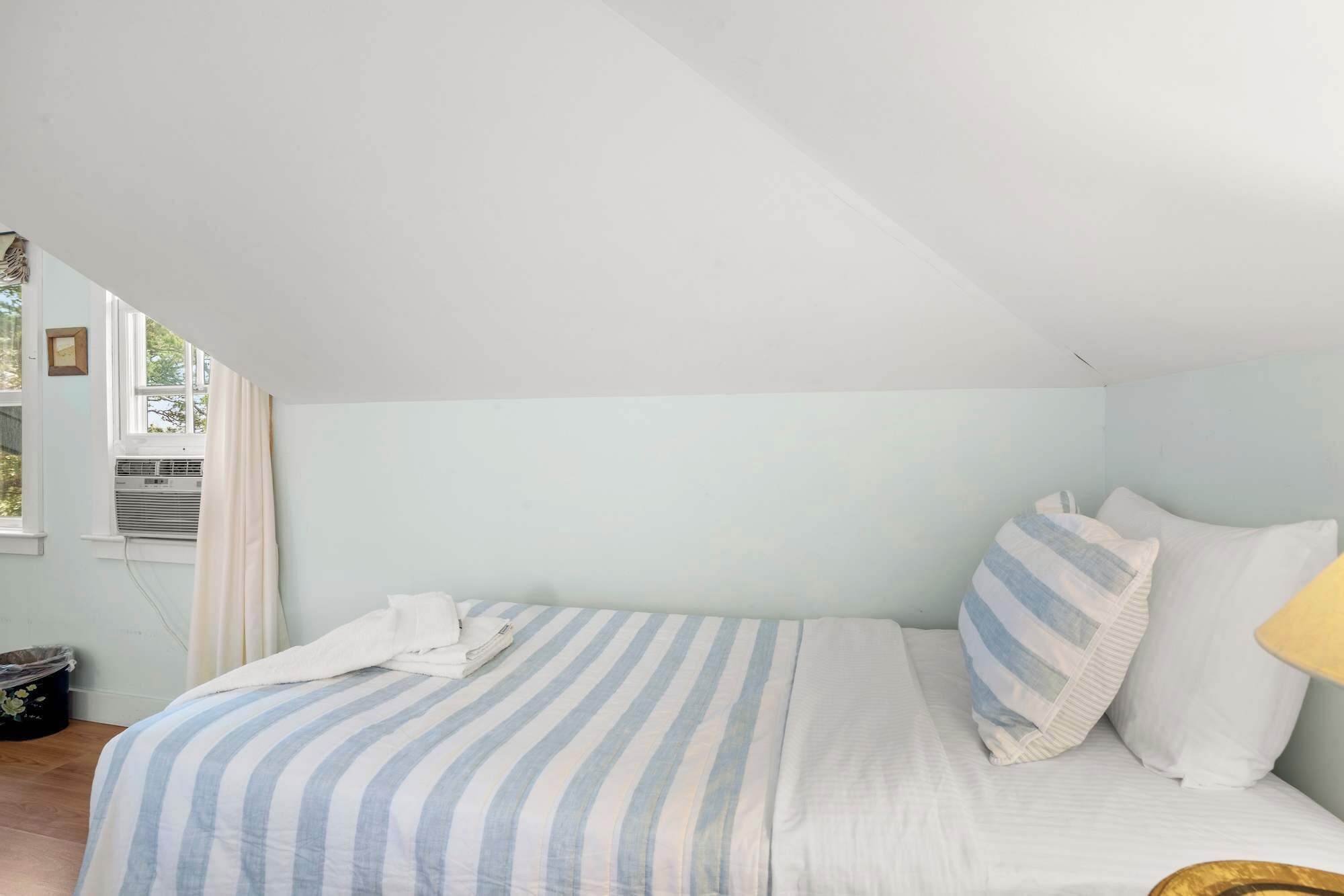 Ein Schlafzimmer mit Bett, Fenster und Heizkörper.