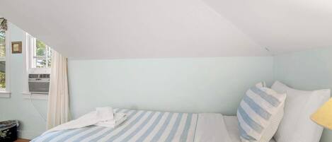 Ein Schlafzimmer mit Bett, Fenster und Heizkörper.