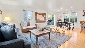 Ein geräumiges Wohnzimmer mit Sofa, Couchtisch und Essbereich mit Stühlen.