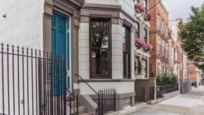 A row of townhouses with a white facade, a blue door, and a black window frame. - Historic Penthouse Style Loft in OTR, Parking Included (Cincinnati)
