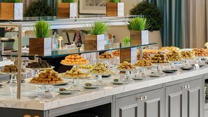 A buffet setup with various food items, glassware, and decorative plants. - Address Jabal Omar Makkah (Makkah)