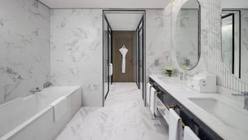 A modern bathroom with a large mirror, a bathtub, and a shower.