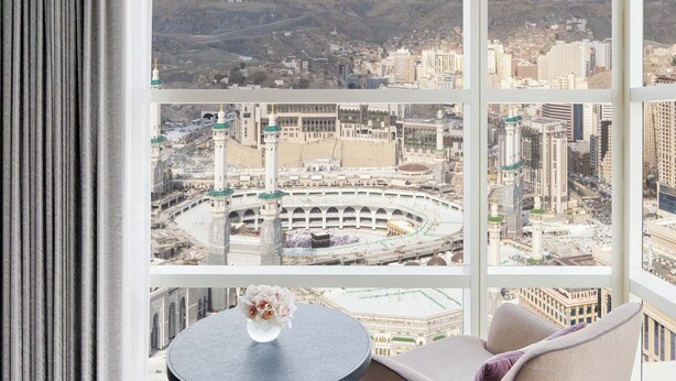 A room with a large window offering a view of a cityscape and mountains. - Address Jabal Omar Makkah (Makkah)