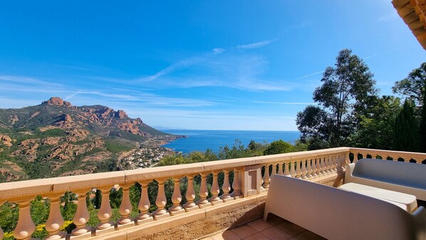 Un balcón con vistas a un paisaje montañoso y al mar.
