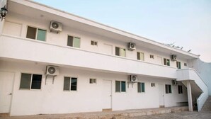 Un edificio a più piani con condizionatori, finestre e una scala.