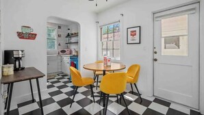 A compact kitchen with a checkered floor, a dining table with four chairs, a ceiling fan, and a door with a window. - Darling Paso Cottage 2blks DT/2 King Bds/Firept/ (Paso Robles)