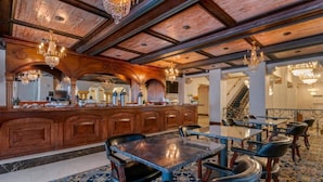 A spacious lobby with a wooden reception desk, multiple seating areas, and ornate chandeliers. - Bposhtels Tampa (Tampa)