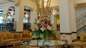 A grand lobby with a large chandelier, ornate columns, and classic furniture. - Bposhtels Tampa (Tampa)