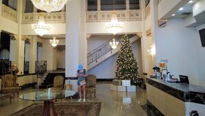 A grand lobby with chandeliers, a staircase, and a decorated Christmas tree. - Bposhtels Tampa (Tampa)