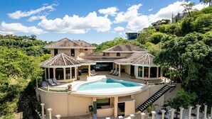 Une grande maison avec une piscine, de nombreuses pièces et un patio couvert.