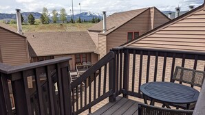 A deck with a table and chairs, overlooking a mountainous landscape. - Cozy In-Town Condo | Pool | Hot Tub | Sauna (Durango)