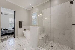 Une salle de bain moderne avec une douche Ă parois de verre, une baignoire blanche et des toilettes.
