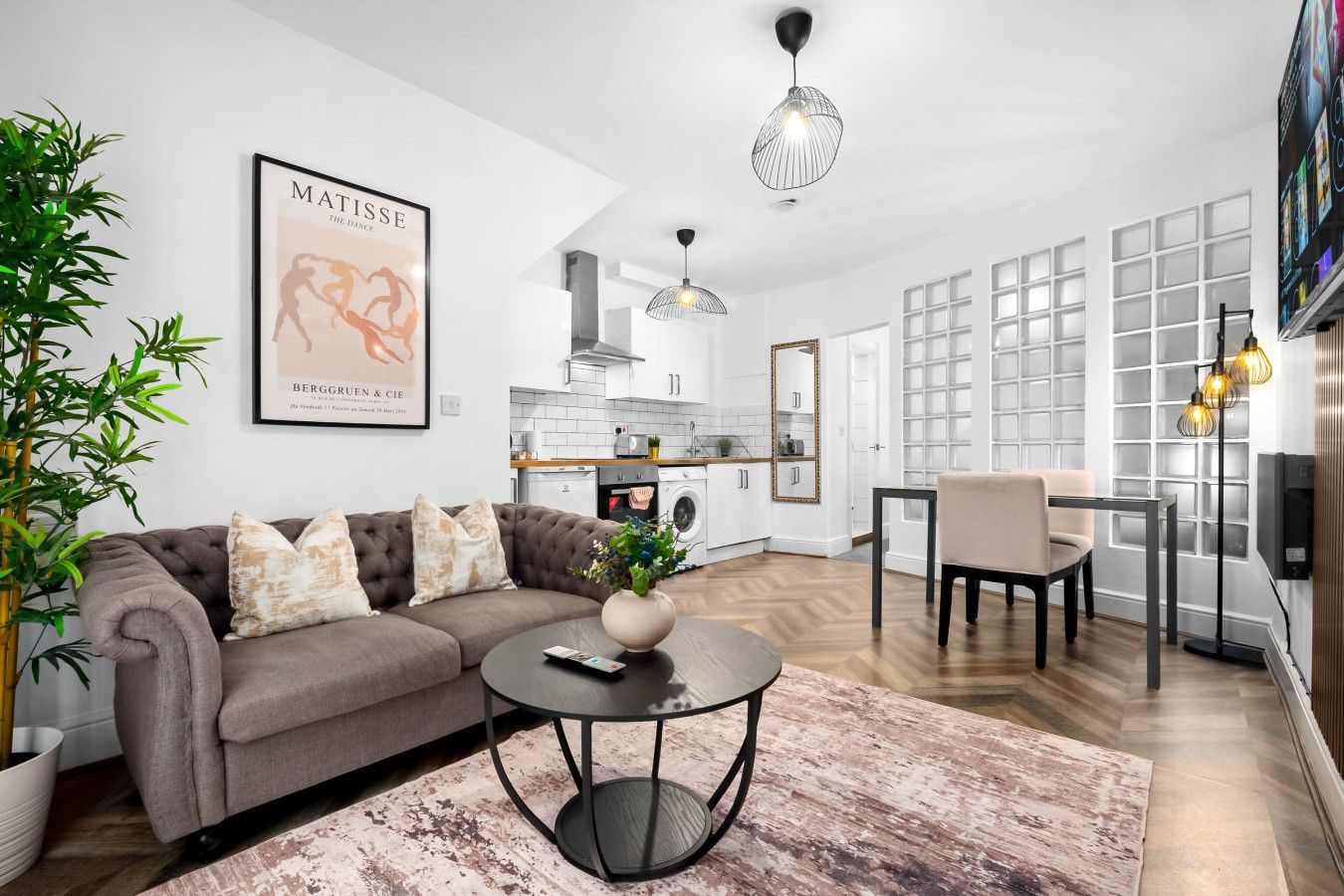 A modern living room with a sofa, coffee table, and a dining area with a chair.