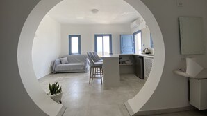Un espacio moderno para vivir con un marco circular que ofrece vistas, un sofá, una zona de comedor y una cocina.