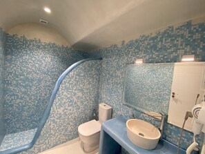 Ein Badezimmer mit Dusche, Toilette, Waschbecken und Spiegel.