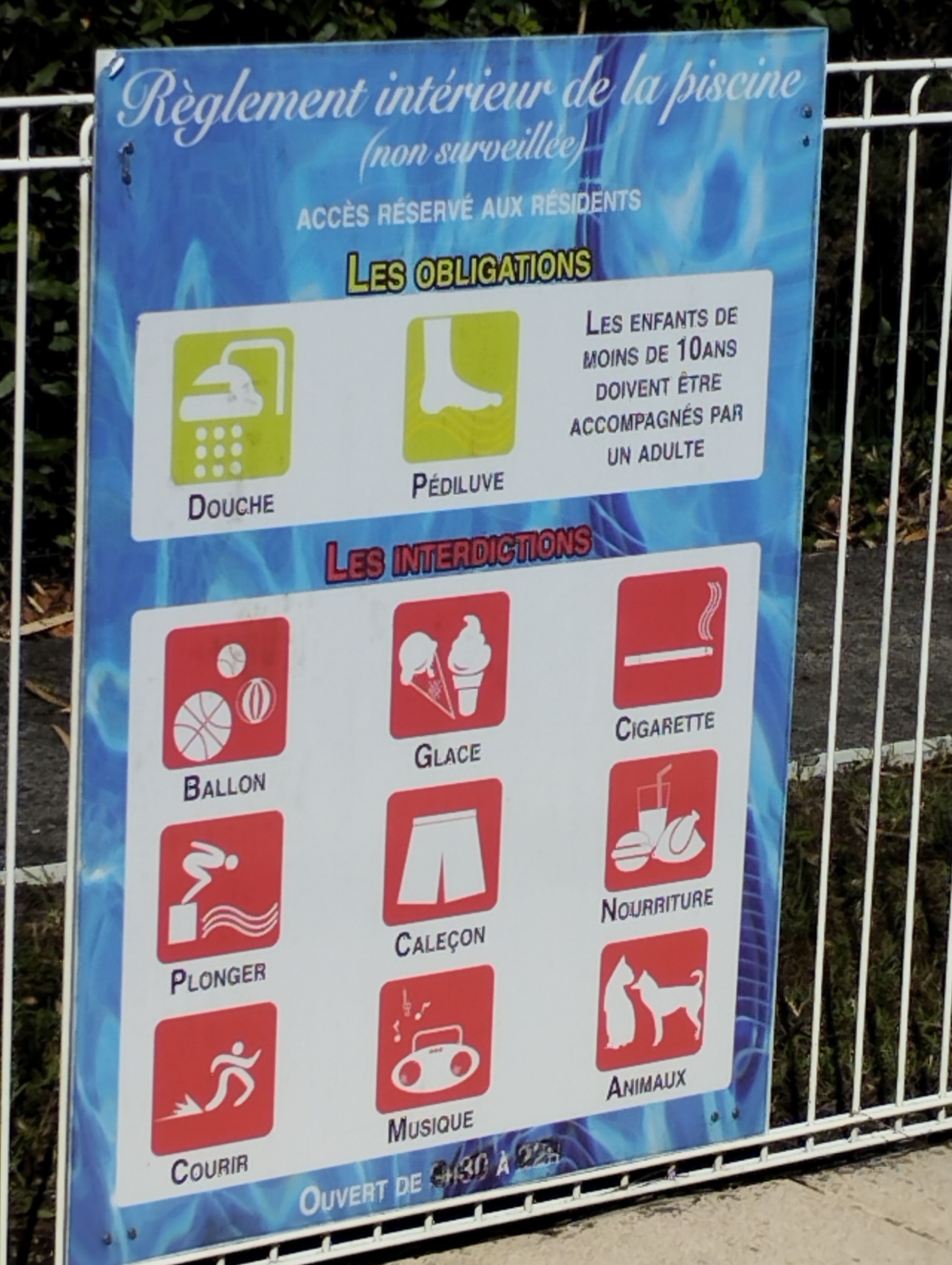 A sign listing pool rules and prohibited items.