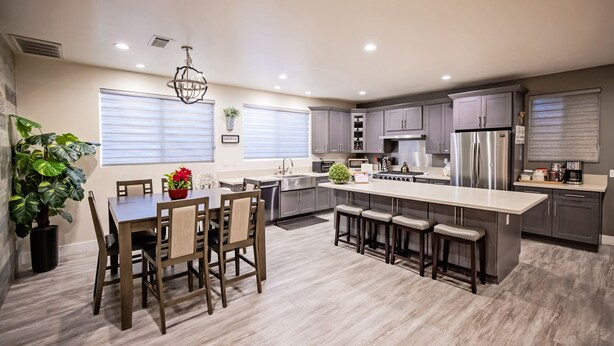 A modern kitchen with a central island, grey cabinets, stainless steel appliances, and a dining area with wooden chairs and a table. - #2*Disneyland 8minutes*Anaheim Convention*Knott*Beaches (Anaheim)