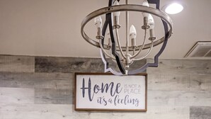 A dining area with a wooden table, a chandelier, a framed quote on the wall, and decorative snowflakes. - #2*Disneyland 8minutes*Anaheim Convention*Knott*Beaches (Anaheim)