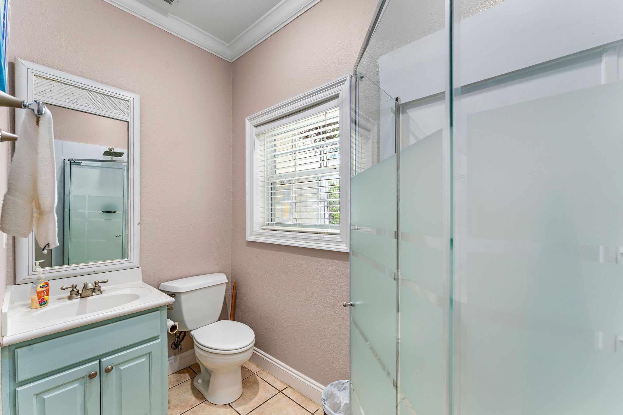Un baño con inodoro, lavabo y cabina de ducha de vidrio.
