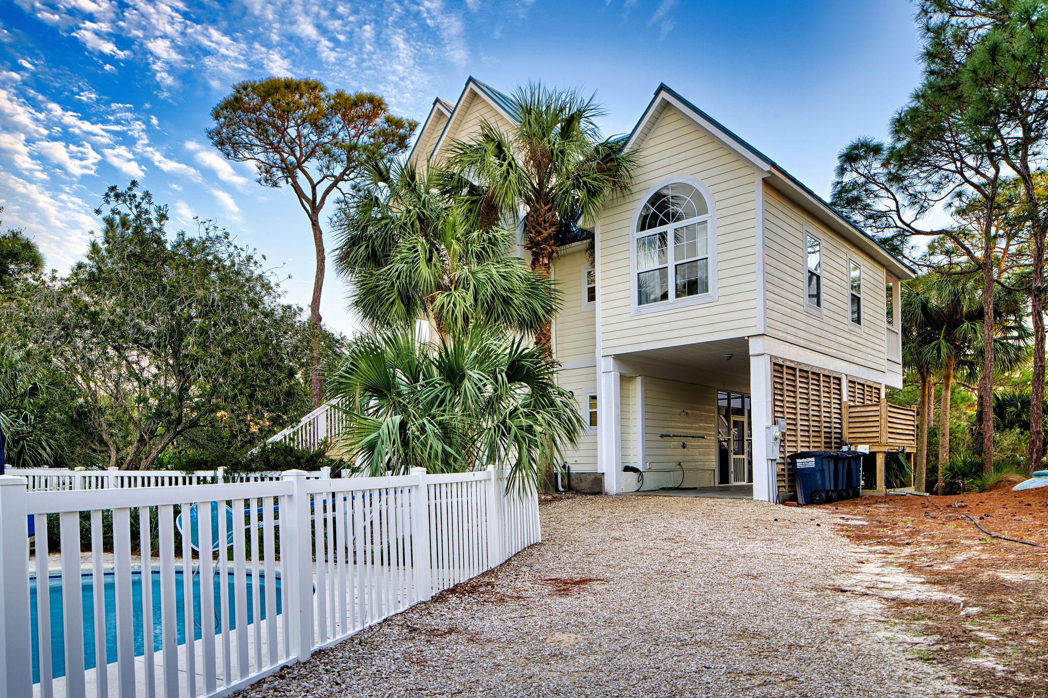 A two-story house with a covered porch, a swimming pool, and a fenced yard.
