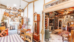 A vintage room with a checkered floor, wooden furniture, and a large clock. - The Burrow (Chickamauga)