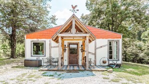 A rustic cabin with a red roof, wooden beams, and a small porch. - The Burrow (Chickamauga)
