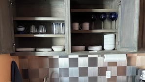 A kitchen with a sink, cabinets, and a tiled backsplash.