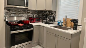 Eine moderne Küche mit Edelstahlgeräten, einer Mikrowelle, einem roten Elektroherd und einem schwarzen Toaster.