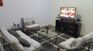 Relax in this inviting living space with a sofa, armchair, and flat-screen TV.