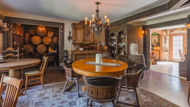 Een traditionele eetkamer met een ronde houten tafel, stoelen en een kroonluchter.