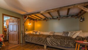 Een gezellig slaapkamer met een groot bed, houten balken en een rustieke uitstraling.