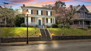 A two-story house with a front porch, a staircase leading to the entrance, and a street lamp. - Private Historic House, in Downtown Bristol Virginia! (Bristol)
