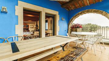 Un comedor con mesa y sillas de madera, un arco y vistas al exterior.