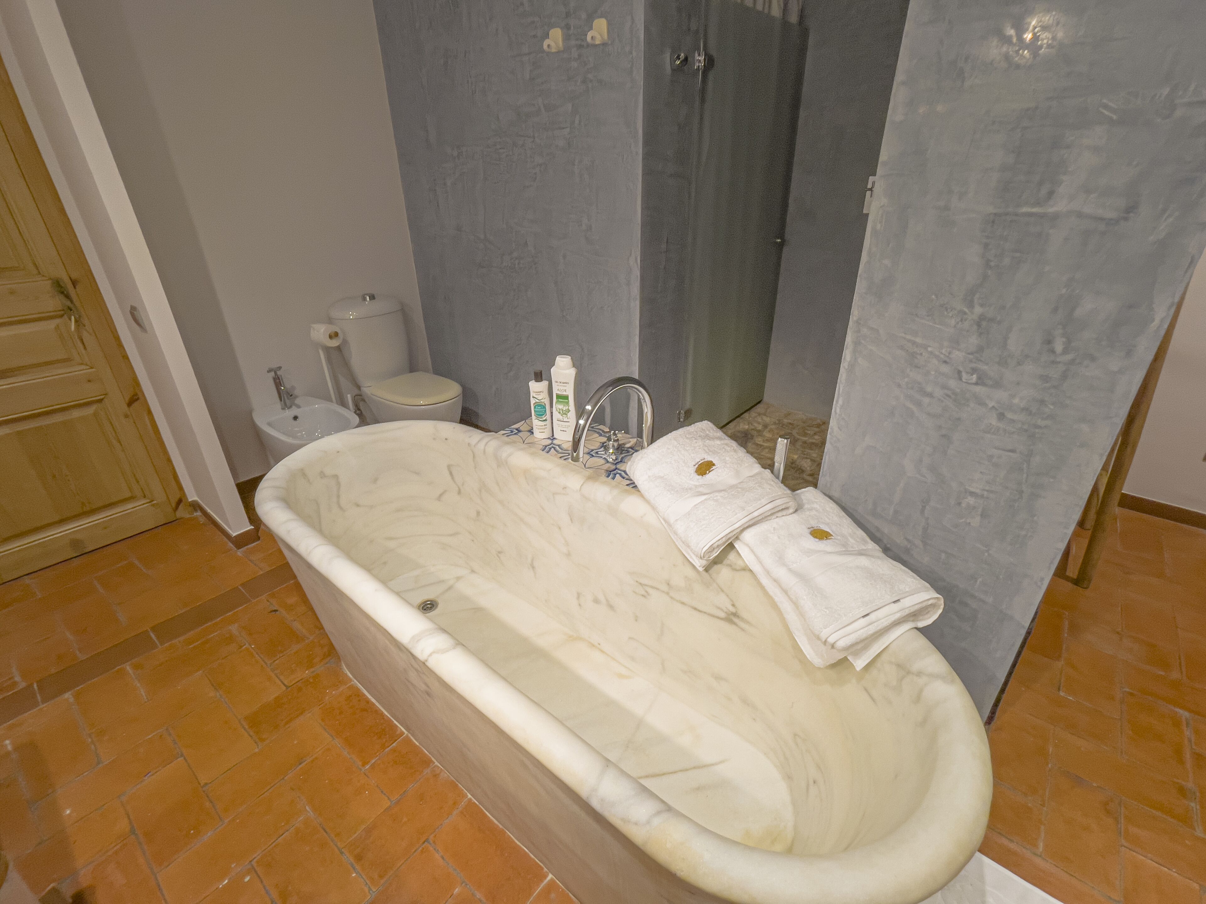 Une salle de bain avec une baignoire sur pieds, des toilettes et un bidet.